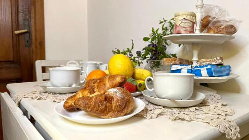 einen Tisch mit Croissants und Tassen Kaffee und Brot in der Unterkunft La cicala in Rosignano Marittimo