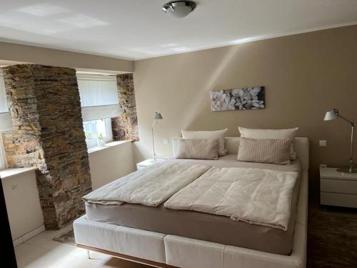um quarto com uma cama grande e uma parede de pedra em Moderne luxuriöse Wohnung em Lüdenscheid