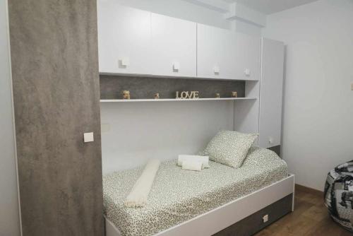 un dormitorio pequeño con una cama con un signo de amor. en El rinconcito de lola, en Candelaria