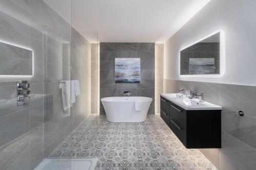uma casa de banho com uma banheira branca e um lavatório. em Killarney Heights Hotel em Killarney