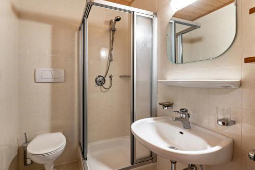 uma casa de banho com um chuveiro, um lavatório e um WC. em Taufner Apartement B 107 em Parcines