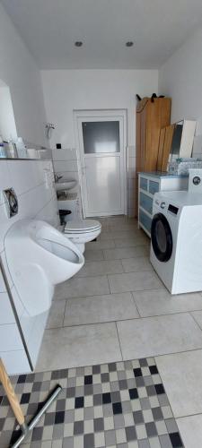 ein Badezimmer mit 2 WCs und einer Waschmaschine in der Unterkunft Urlaub im Bauwagen in Mörlenbach