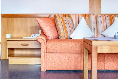 a couch with pillows on it next to a table at Taufner Apartement B 107 in Parcines