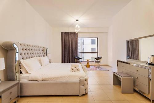 a bedroom with a bed and a dresser and a mirror at Leen Homes-JBR -Spacious 4 Bedroom apartment in Dubai