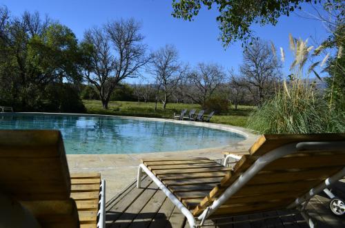 una piscina con 2 tumbonas junto a ella en Manantial Hostería & Cabañas en Nono