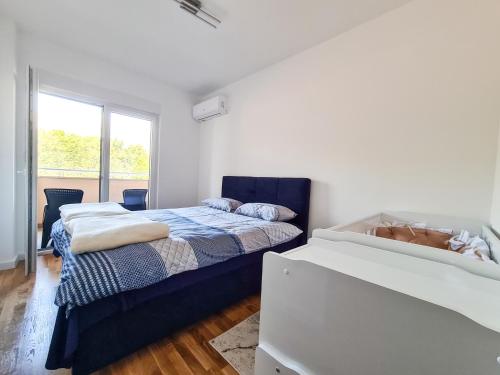 - une chambre blanche avec un lit et une fenêtre dans l'établissement Apartman Valentina, à Trebinje