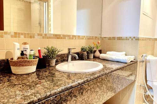 a bathroom counter with a sink and a mirror at Leen Homes-JBR -Spacious 4 Bedroom apartment in Dubai