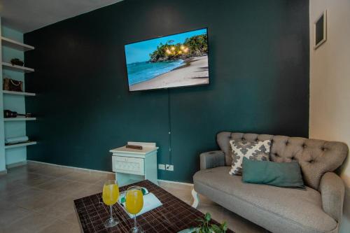 uma sala de estar com um sofá e uma televisão na parede em Nasim Condo Hotel con acceso BEACH CLUB GRATIS, metros 5th AVENIDA em Playa del Carmen