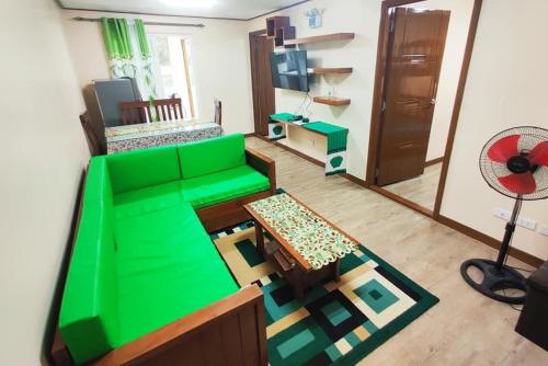 a living room with a green couch and a table at Zenmist Properties- 2 Bedroom Deluxe in Baguio