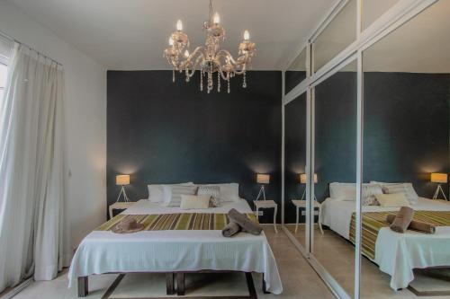 a large bedroom with two beds and a mirror at Nasim Condo Hotel con acceso BEACH CLUB GRATIS, metros 5th AVENIDA in Playa del Carmen