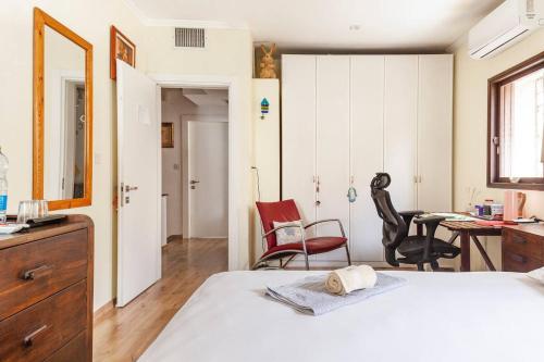 荷茲利亞的住宿－Cosy room near IDC & Center- Herzliya Homestay，卧室配有一张床、一张桌子和椅子