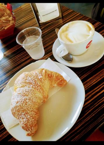 einen Teller mit Gebäck und einer Tasse Kaffee in der Unterkunft Alba b&b in Polignano a Mare
