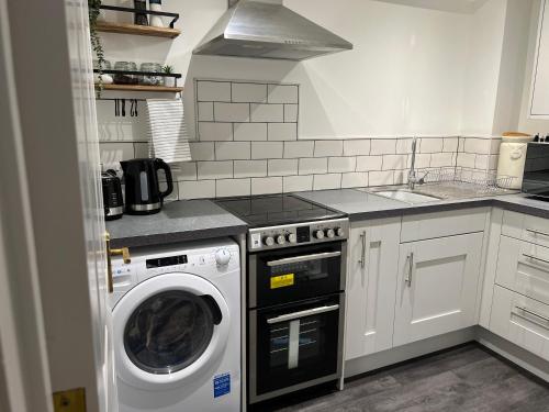 a kitchen with a washing machine and a sink at Ground floor apartment, central location with free parking in Hereford
