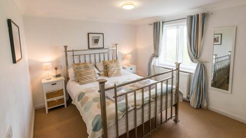 a bedroom with a bed and a window at Chesil Beach Lodge Burton Bradstock Dorset DT64RJ in Bridport