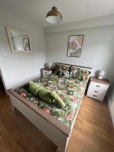 a small bedroom with a bed with a green comforter at Ground floor apartment, central location with free parking in Hereford