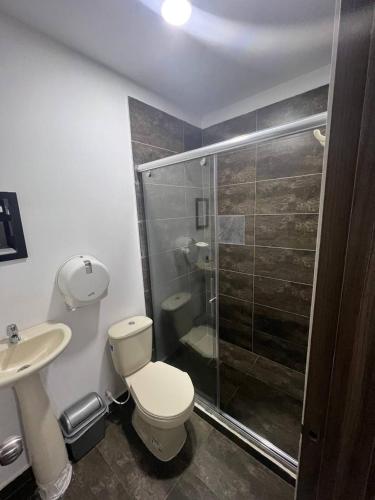 a bathroom with a shower and a toilet and a sink at Hotel Don Felipe in Ríohacha