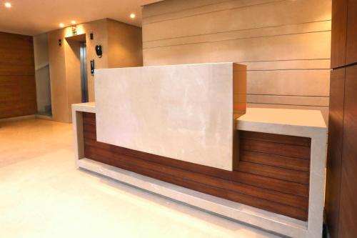 a lobby with a white counter and wooden wall at Sagar Hotel JUST 5 MIN FROM GOLDEN TEMPLE in Amritsar