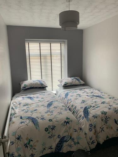 um quarto com 2 camas e uma janela em The Greens Apartment em Farnworth