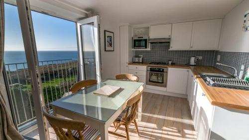 a kitchen with a table and a view of the ocean at Chesil Beach Lodge Burton Bradstock Dorset DT64RJ in Bridport