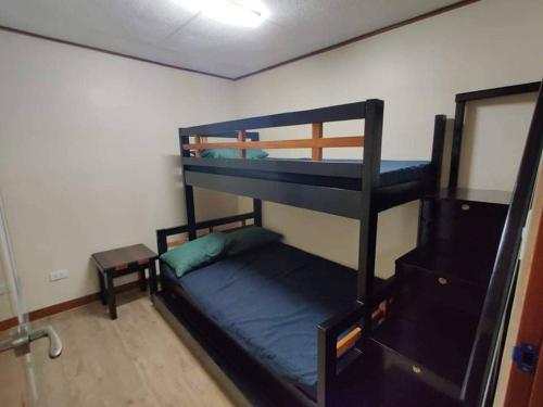 a room with two bunk beds and a table at Zenmist Properties- 2 Bedroom Deluxe in Baguio
