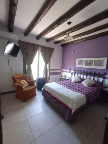 1 dormitorio con 1 cama y 1 silla en La Josefina. en Maipú