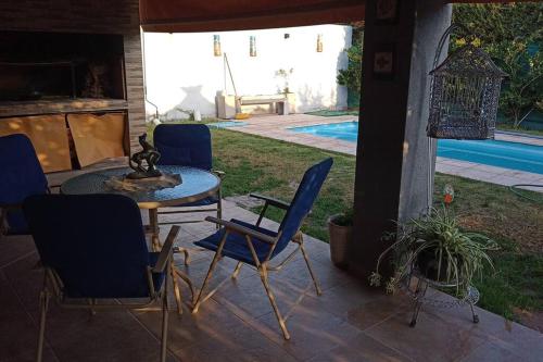 un patio con sillas, una mesa y una piscina en La Josefina. en Maipú