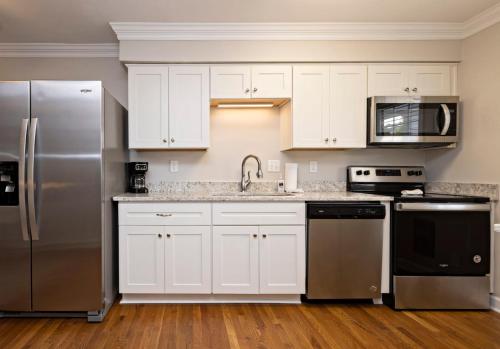 uma cozinha com armários brancos e electrodomésticos de aço inoxidável em Natural Beauty B em Virginia Beach