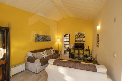 a living room with two couches and a yellow wall at Casa Aconchego by AcasaDasCasas in Mafra