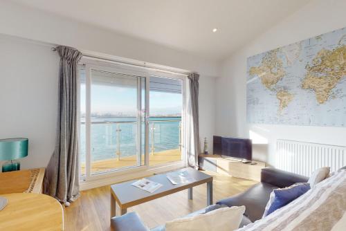 a living room with a large window with a view of the ocean at Crabbers' Wharf in Portland