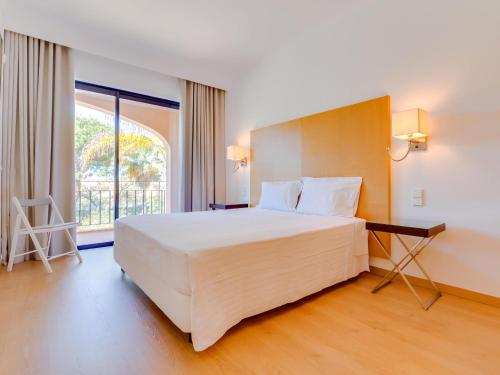 une chambre avec un grand lit et une grande fenêtre dans l'établissement AL - Apartamento Vila Sol AG, à Vilamoura