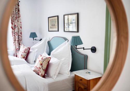 a bedroom with a white bed with pillows and a mirror at Luxuriöses Bauernhaus in Seenähe in Altaussee