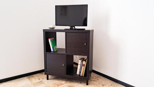 a black book shelf with a television on top at Casa Marina - Spacious Home in Rapallo in Rapallo
