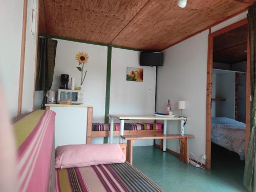 une chambre avec un lit, un bureau et une table dans l'établissement Chalet simple au Camping L'Etruyere au lac, à La Tardière