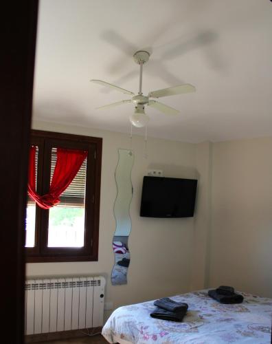 a bedroom with a ceiling fan and a bed at El Rincón de Doina in Alquézar