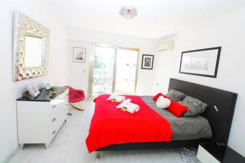 1 dormitorio con cama roja y manta roja en Le Regency YourHostHelper 4* en Antibes