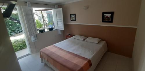 1 dormitorio con cama y ventana grande en Ecopousada Miriti, en Belém