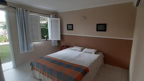 a bedroom with a bed and a window at Ecopousada Miriti in Belém