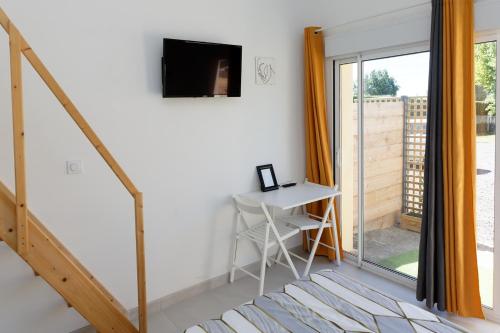 a living room with a desk and a sliding glass door at Le Cocon de Lily in Saint-Savin-de-Blay