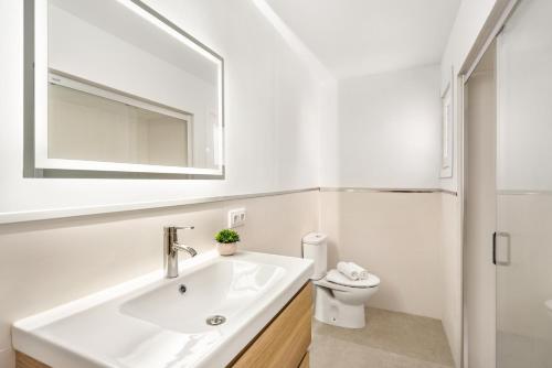 a white bathroom with a sink and a mirror at Villa Misuco in Son Parc