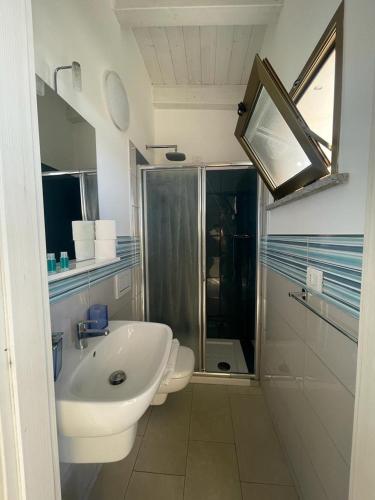 a bathroom with a sink and a toilet and a shower at La Tonnara B&B in Palmi