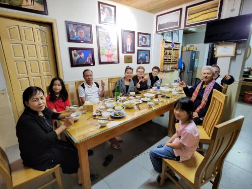 a group of people sitting around a table at Huy Trung Homestay in Bắc Hà