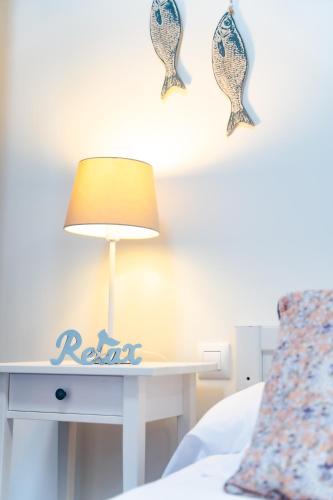 a table with a lamp on top of a bed at Apartamentos Costa Norte in San Vicente de la Barquera
