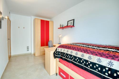 a bedroom with a bed and a red and white blanket at Lola in L'Escala