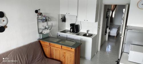 une petite cuisine avec un évier et un micro-ondes dans l'établissement Appartement T2 avec vue - Port Leucate - 4 personnes, à Leucate
