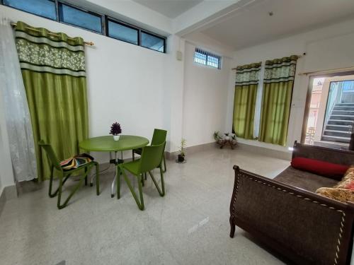 a living room with a table and chairs and a couch at Purabi's Nest in Tezpur