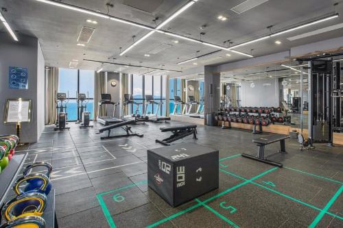 un gimnasio con mesas de ping pong y bancos. en Homie Panorama Beachfront Residences Nha Trang en Nha Trang