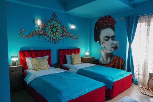 ein Zimmer mit 2 Betten und einem Wandbild einer Frau in der Unterkunft Hotel Pamela Concept in Negotino