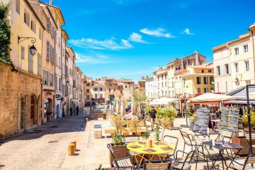 una calle de la ciudad con mesas, sillas y edificios en Maison Planier, havre de paix proche mer et centre, en Sausset-les-Pins