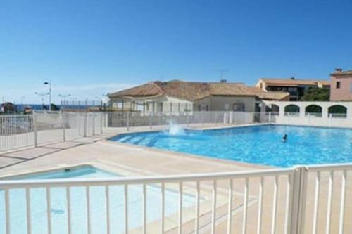 une grande piscine entourée d'une clôture blanche. dans l'établissement Maison Planier, havre de paix proche mer et centre, à Sausset-les-Pins