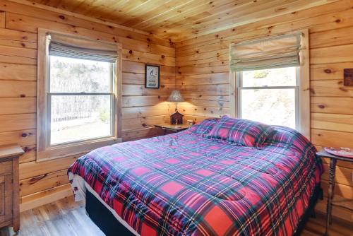 a bedroom with a bed in a log cabin at Riverfront Rumney Vacation Rental with Fire Pit! in Rumney